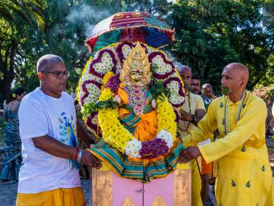 In tanti sono attorno alla statua (murti) raffigurante la dea Mariamman, il cui volto in ottone dorato, impreziosito da gioielli e da un elaborato copricapo, � posto al centro di una cornice di fiori bianchi, viola e gialli
